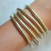 Set of 5 gold bangles on arm