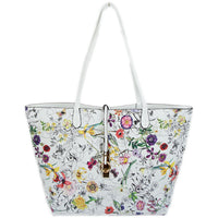 White background with florals in yellow, pink, purple, green and gray. This floral bag reverses to a solid white tote with a floral over the shoulder zippered bag inside that can be worn alone.