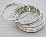 Set of 12 delicate silver bangles