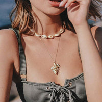 Young woman wearing Cowrie Shell necklace layered with a NON-bella shell on chain