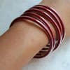 Set of 5 red bangles on arm